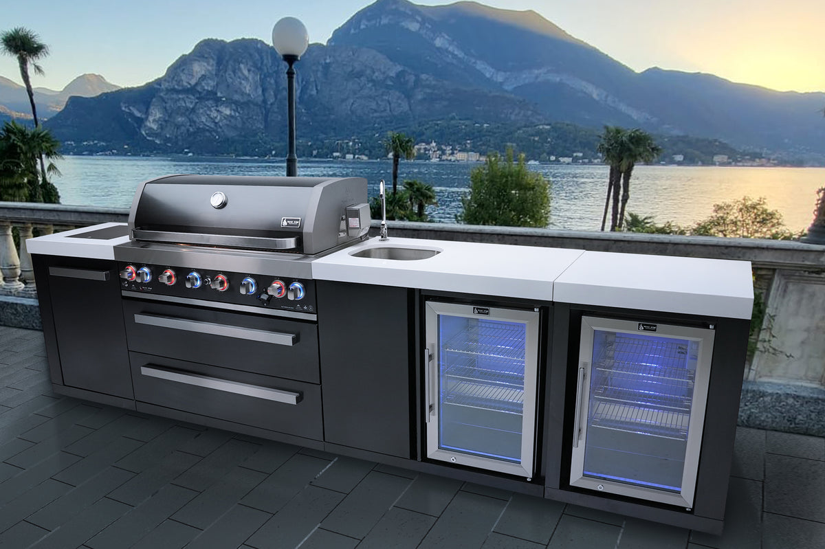 Supplier lifestyle image of the Mont Alpi MAi805-BSSBEVFC Black Series kitchen with beverage center and two fridges on a lakeside patio