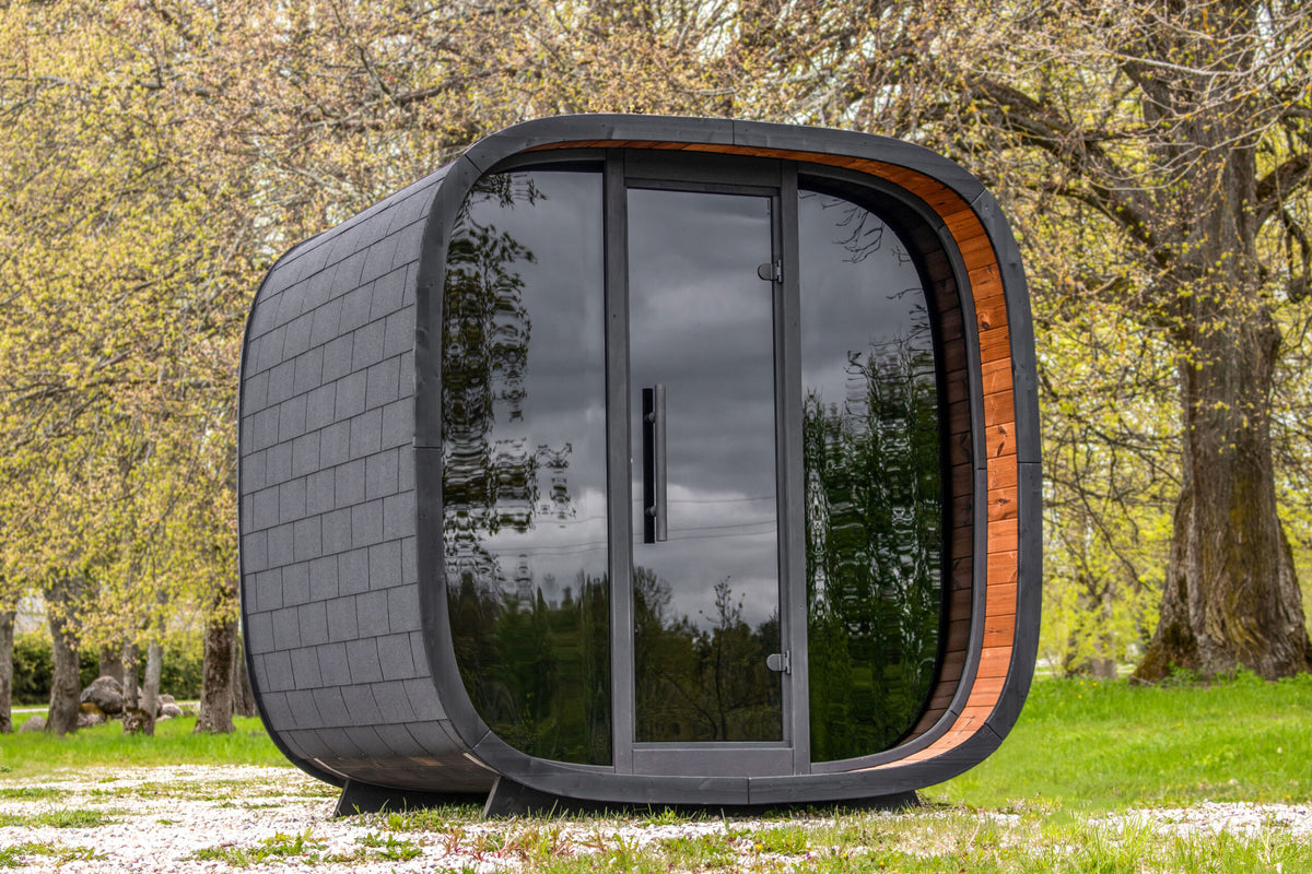 LEIL Round Cube Mini photographed in a garden with reflective glazing