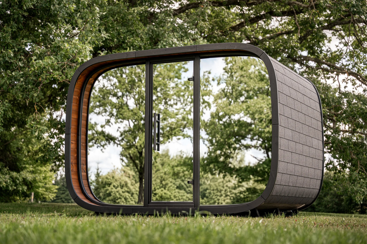 LEIL Round Cube Relax 2.0 outdoor sauna with reflective glazing in a leafy garden